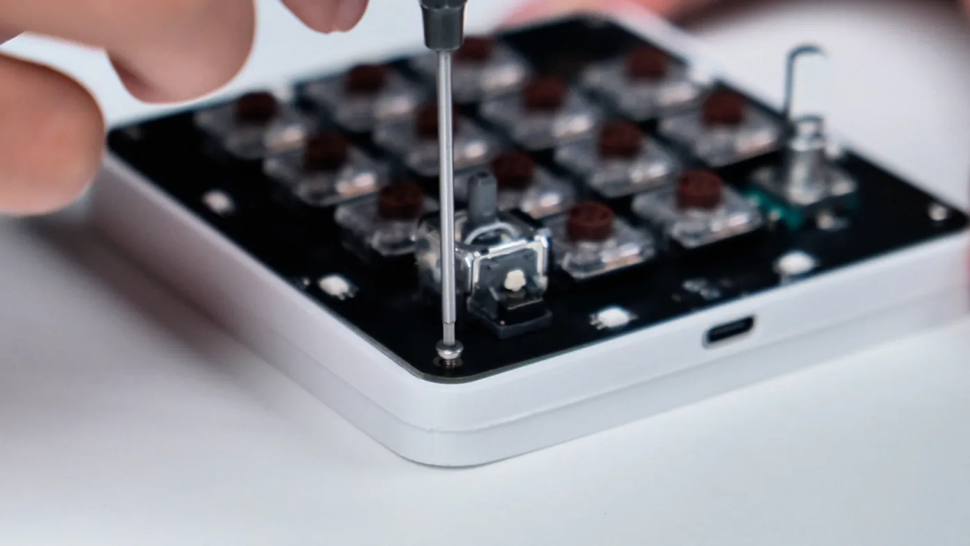Securing the PCB into the white 3D-printed enclosure with a corner screw